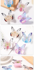 Close-up of translucent butterfly hair claws with bionic wing patterns and metal springs
