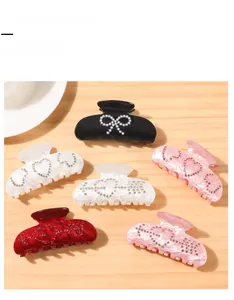 Close-up of hair claws with marble texture, imitation pearls, and rhinestone accents