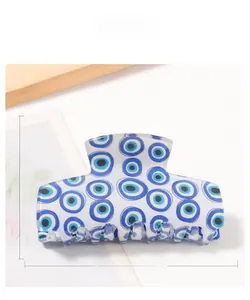 Macro detail of rectangle evil eye hair claw clip with size measurements 8.9cm x 4.8cm