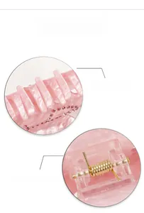 Detail of pink marble hair claw clip featuring rhinestones and a strong golden spring