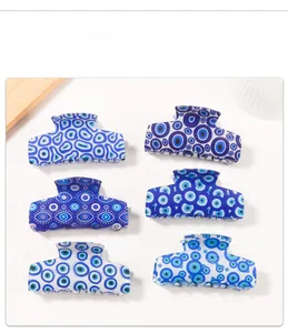 Close-up set of six blue and white rectangular hair claws with Evil Eye patterns