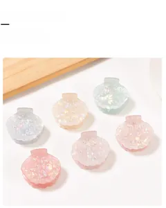 Detailed close-up of shell-shaped hair claw clips with pearl accents in multiple colors