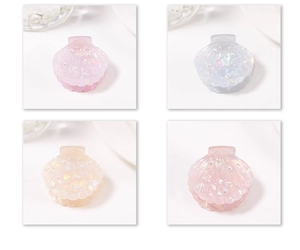 Macro detail of shell-shaped hair clips with iridescent finish and pearl accents in four colors
