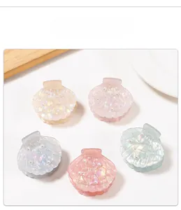 Detailed view of shell-shaped hair claws in five pastel colors with pearl decorations