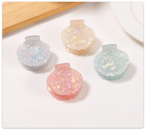 Set of shell-shaped hair clips with pearl accents in pearl blue, yellow, pink, and green