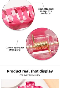 Detail of pink heart hair claw clip showing the smooth surface and gold metal spring