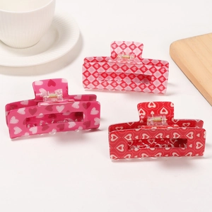 Three-piece set of heart-patterned hair claws in pink and red acrylic with metal spring