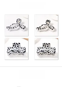 Detail view of cow print resin hair claws in butterfly and rectangular shapes
