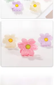 Dettaglio di piccoli fermagli per capelli a forma di fiore in colori pastello sfumati