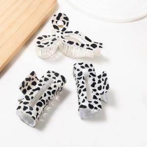 Three-piece set of black and white cow print hair claws including a bow and rectangular shapes