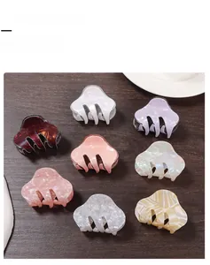 Close-up of nine colorful glossy acetate hair claw clips in various marbled patterns