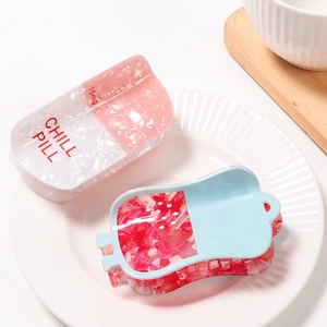 Whimsical pill-shaped acetate hair claw clips with Chill Pill text on a ceramic plate