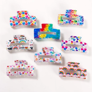 Eight colorful PVC hair claw clips with rainbow patterns and PRIDE slogans on white background