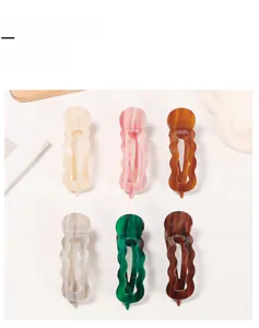 Dettaglio di sei mollette per capelli con trama marmorea in vari colori eleganti