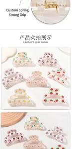 Detail of the golden metal spring and diverse fruit patterns on small hair claw clips