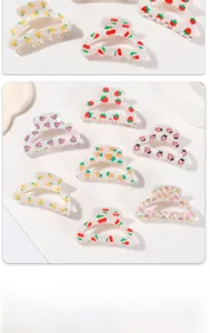 Detail showing various fruit-shaped acetate hair claws with a pearlescent finish