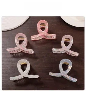 Close-up of five iridescent acetate hair claws with twisted design and pearl luster finish