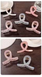 Close-up of iridescent hair claws with pearl finish and golden metal springs