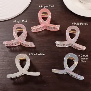 Elegant pearlescent ribbon hair claws in multiple colors on dark wood background