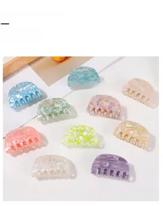 Detail showing ten colorful marble-patterned PVC hair claw clips in various vibrant shades