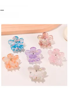Dettaglio di sei mollette per capelli floreali colorate in acrilico con finitura glitter