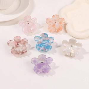 Set di sei mollette per capelli a forma di fiore colorato con strass su sfondo bianco