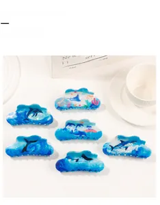 Detailed set of six ocean-themed hair claws featuring blue shark and dolphin patterns