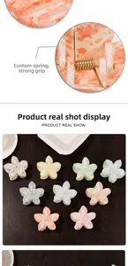 Detail of high-grip metal spring and colorful floral claw clips with marble texture