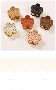 Detail of six floral hair claws in assorted colors with metallic rivet accents