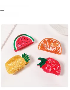 Close-up of acetate fruit hair claw clips with translucent watermelon and orange patterns