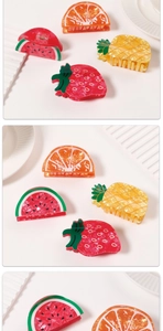 Detail view of fruit-shaped hair claws including watermelon, pineapple, and strawberry designs