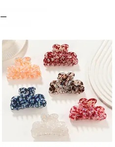 Set of six assorted ink texture hair claw clips in vibrant colors on a ripple surface