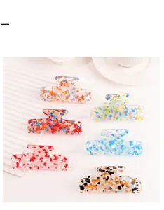 Set of 6 clear acrylic hair claw clips with colorful glitter sequins in macro view