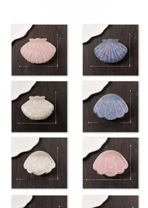 Detail of shell-shaped hair claws with pearlescent finish and rhinestone accents