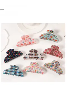 Flat lay of ocean-themed hair claw clips with starfish and seashell patterns on white background