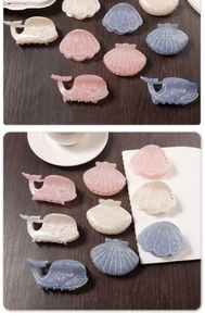Detail showing shell and whale shaped hair clips in pearlescent acetate with fine glitter