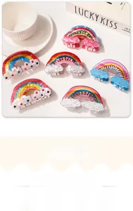 Detailed view of rainbow resin hair claws with white clouds on a lifestyle background