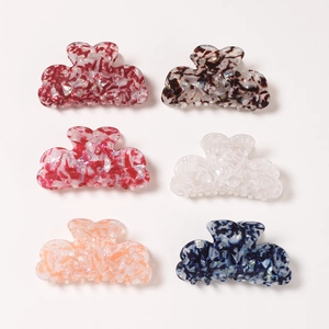 Set of six cloud-shaped marble texture hair claws in various vibrant colors on a grey background
