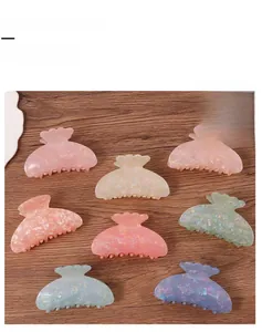 Macro shot of candy-colored petal hair claw clips with pearlescent finish on wood