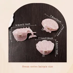 Pink ocean whale and shell hair claws with pearlescent finish on wooden background