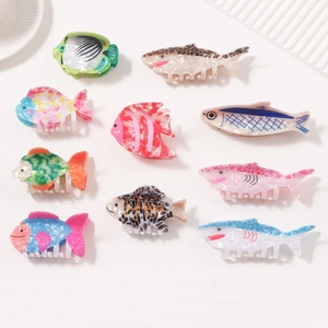 Colorful marine animal hair clips in fish shapes on a minimalist cream background