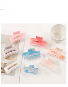 Flat lay of eight colorful marble patterned hair claw clips with decorative props