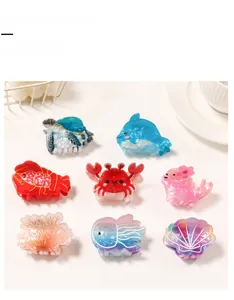 Flat lay of ocean-themed acetate hair claw clips featuring turtle, dolphin, and sea creatures