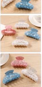 Macro detail of acetate hair claws in pink, white and blue with Aloha rhinestone lettering