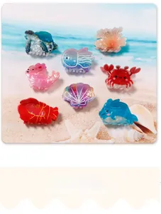 Detailed macro shot of eight ocean-themed acrylic hair clips on a beach setting