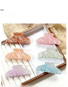 Detailed set of six iridescent hair claw clips in macaron colors on a jewelry tray