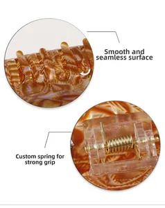 Détail de la texture en résine ambrée et du ressort métallique solide de la pince à cheveux