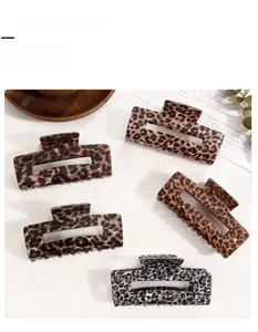 Detail view of five large leopard print hair claw clips in various stylish resin finishes