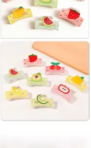 Detailed view of colorful acrylic fruit hair claws including avocado and cherry designs
