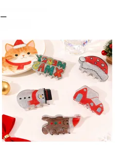 Detail of Christmas glitter hair claw clips featuring gingerbread man and snowman designs